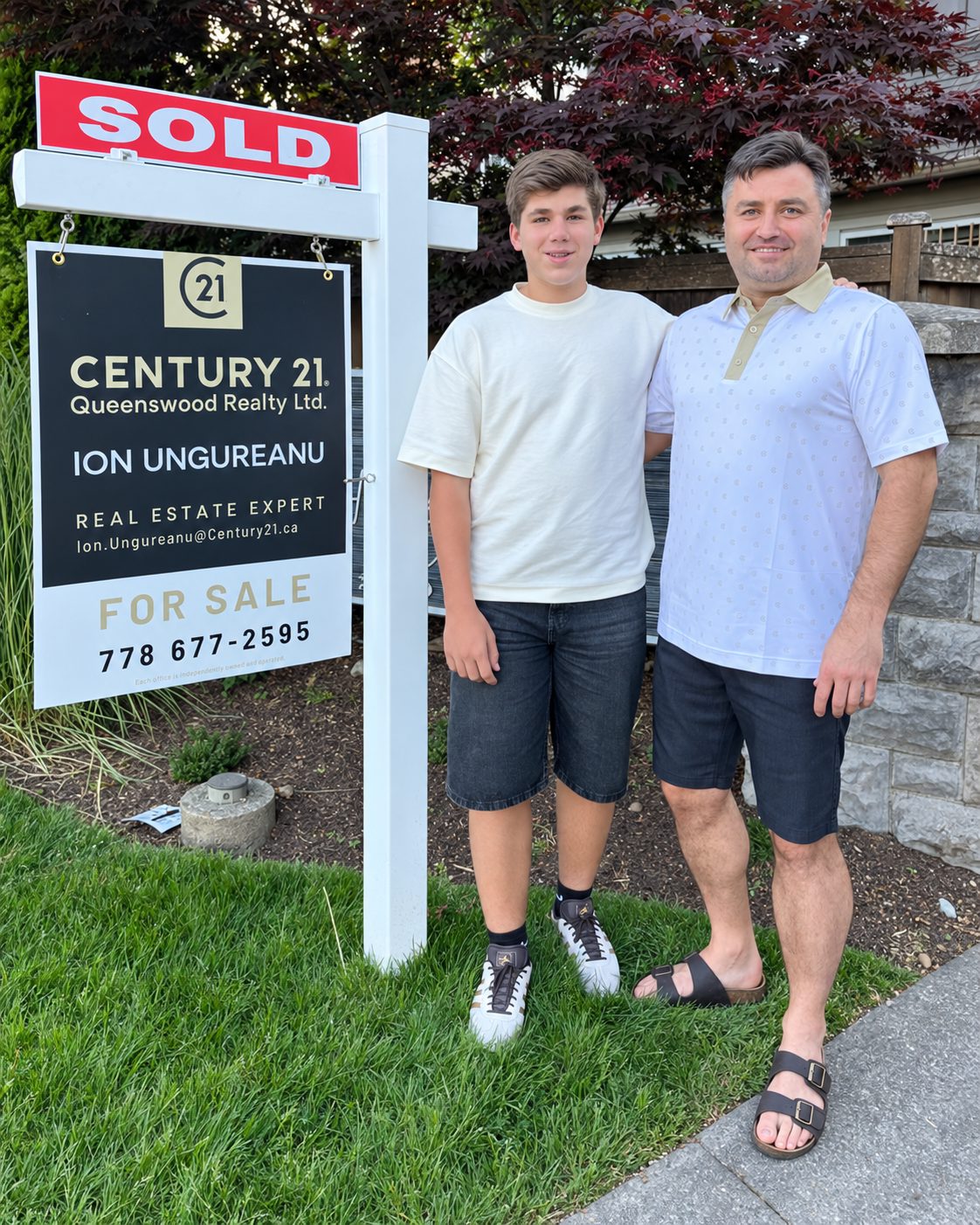 Victoria BC REALTOR® Ion Ungureanu with his son beside a sold CENTURY 21 real estate sign